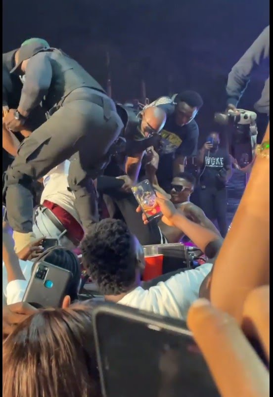 Moment Wizkid Fell On Stage As Two Over-Excited Fans Grabbed His Leg (Video)